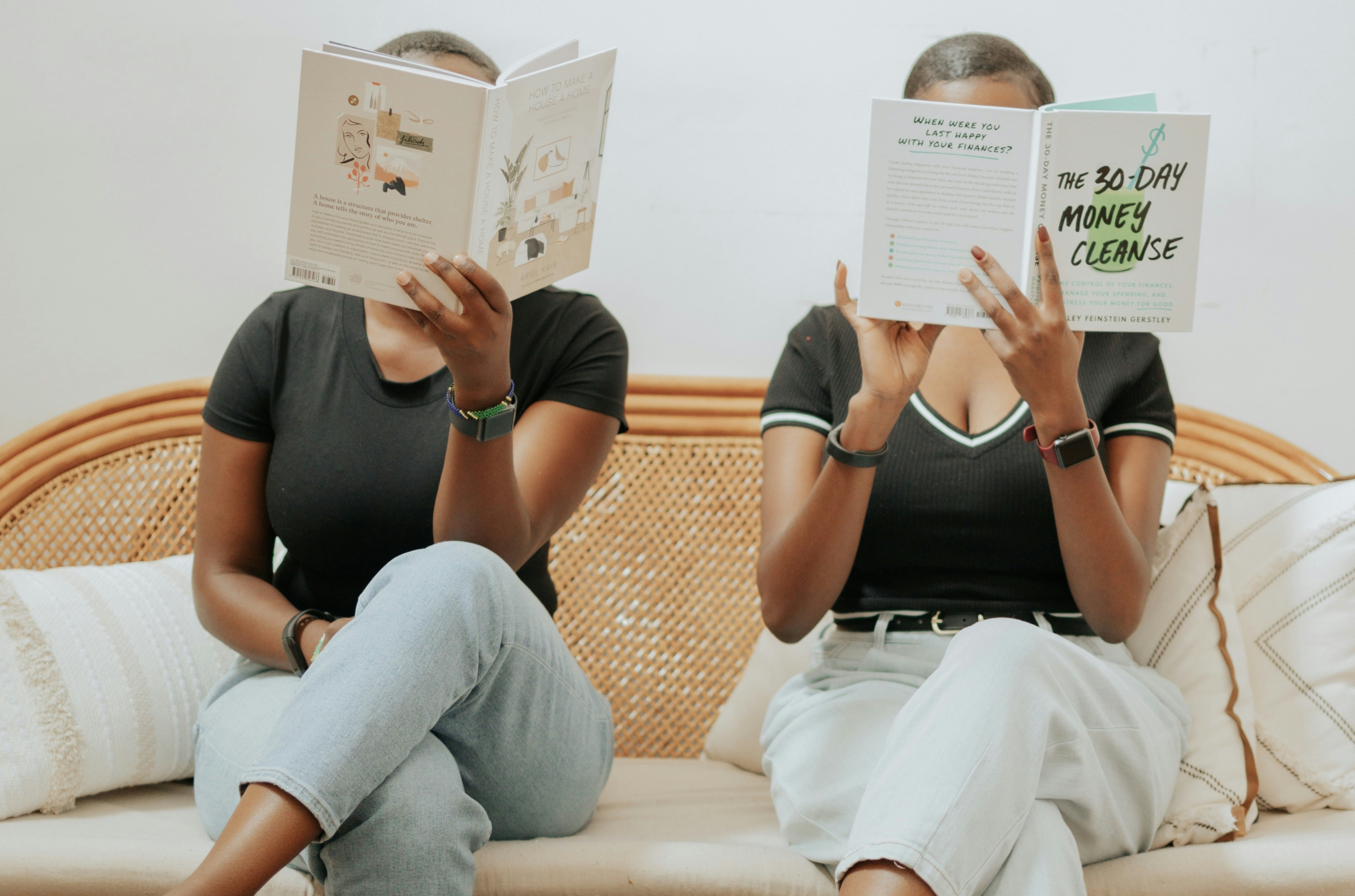 Two Black women reading a book.