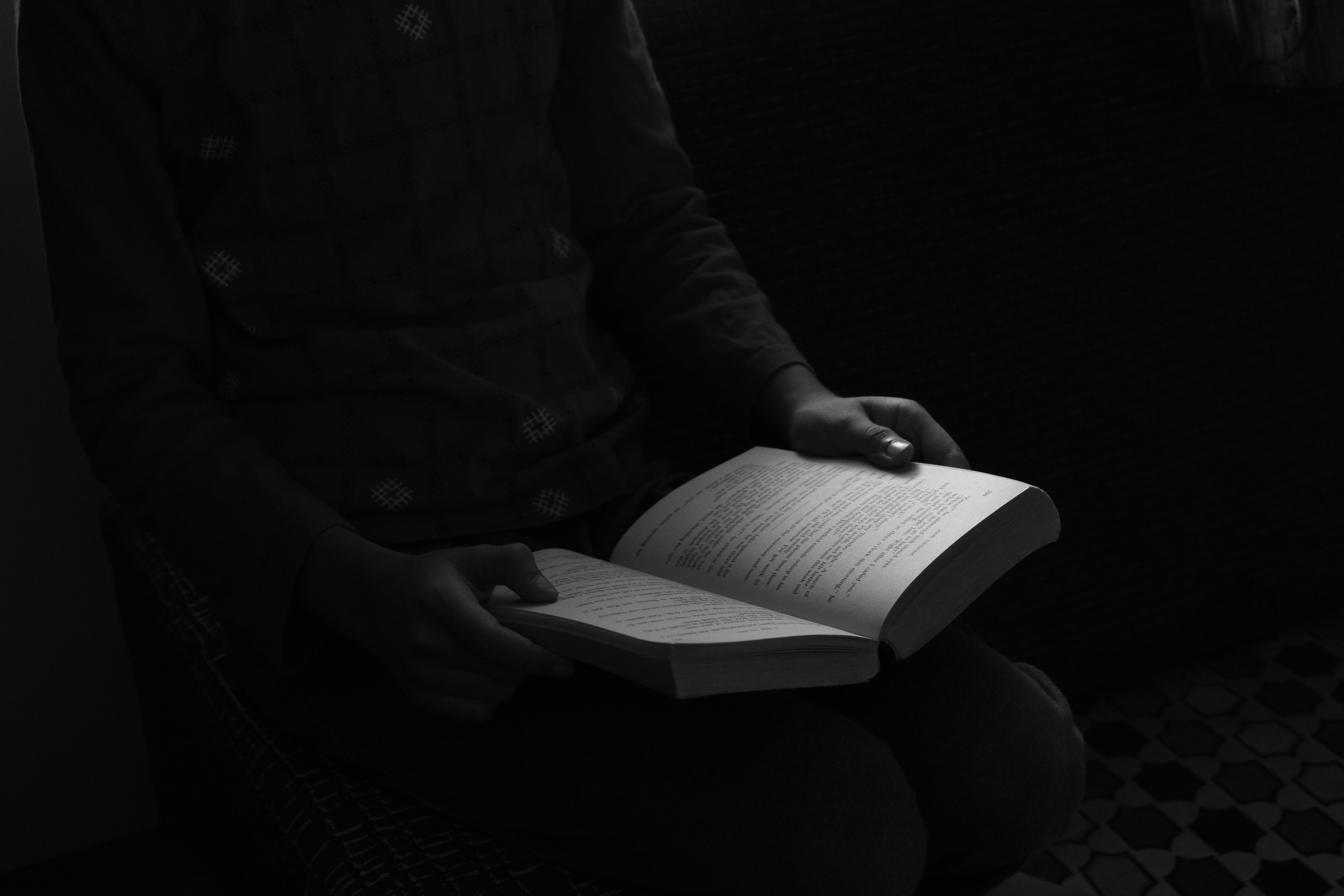 A person holding a book in their lap.